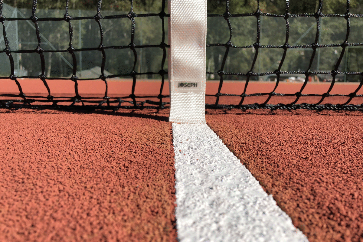 Nahbildaufnahme vom Tennisplatz mit Gummigranulat